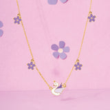 Tiny Jewels necklace with a swan pendant and flower-shaped pendants on a pink background