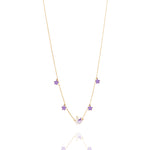 Tiny Jewels gold necklace with purple gemstones on a white background