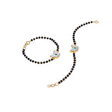 Tiny Jewels black beaded necklace with gold and blue butterfly pendants on a white background