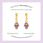 Tiny Jewels gold and purple hamsa hand earrings on a white background with text about Tiny Jewels.
