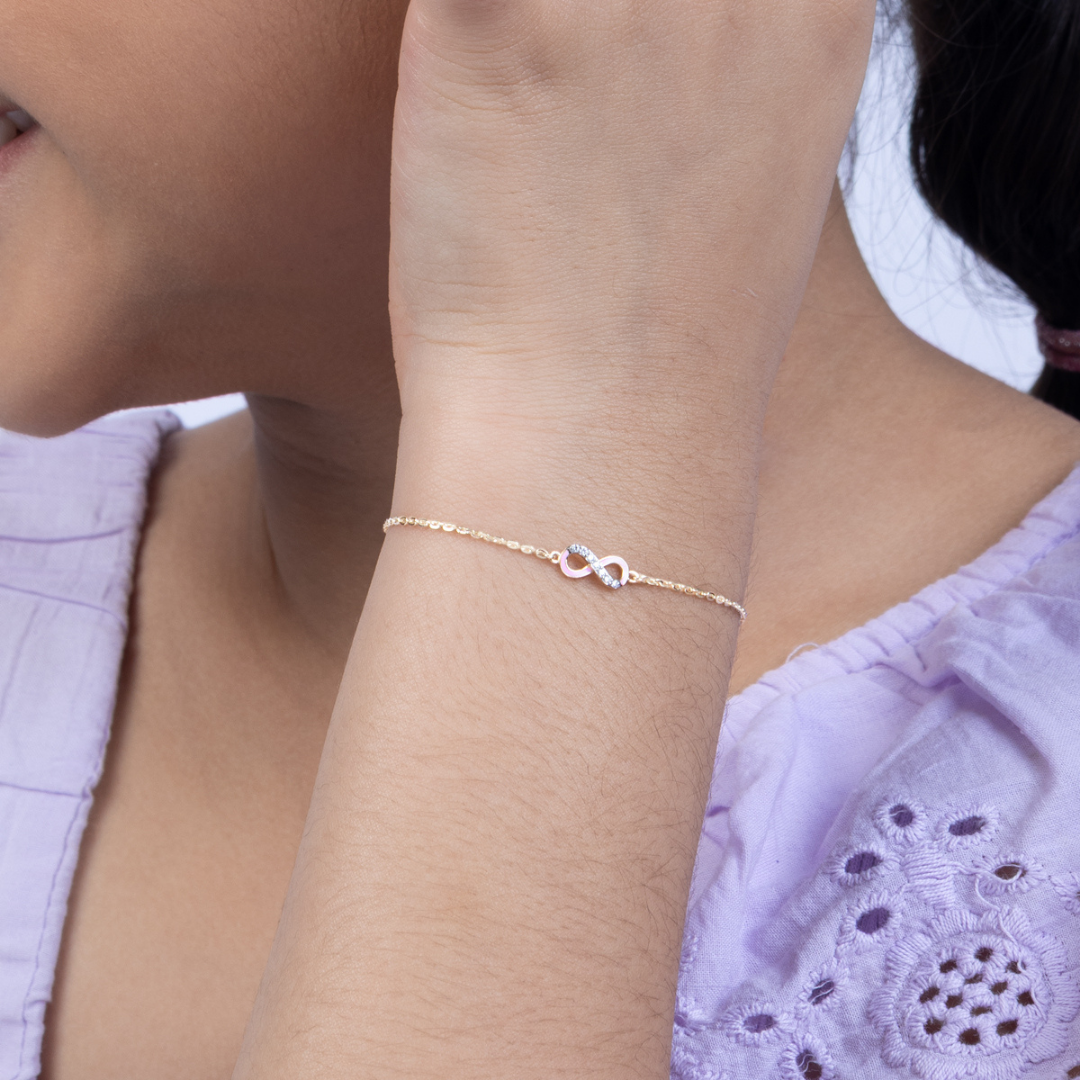 Tiny Jewels rose gold bracelet on a wrist with a blurred background