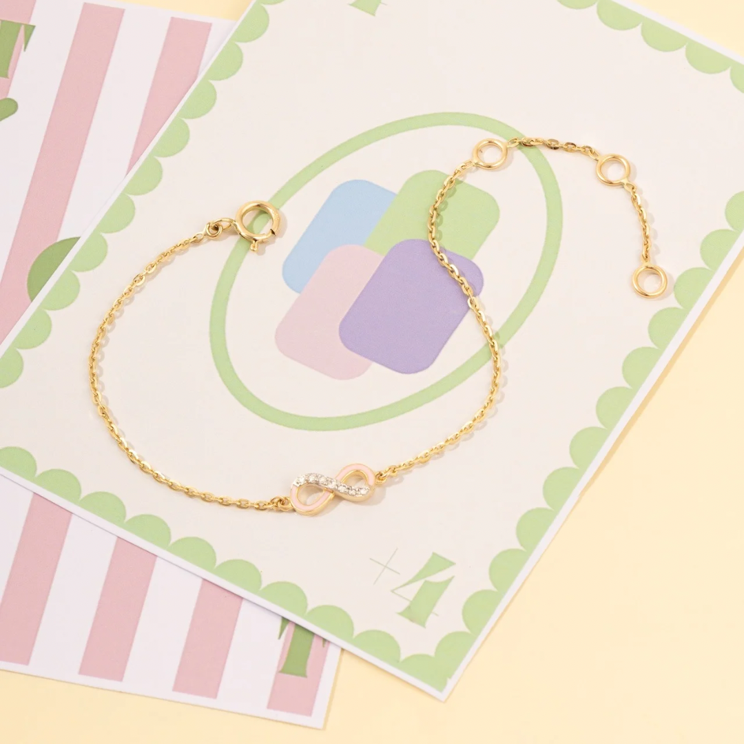 Tiny Jewels gold bracelet on a decorative card with pastel colors