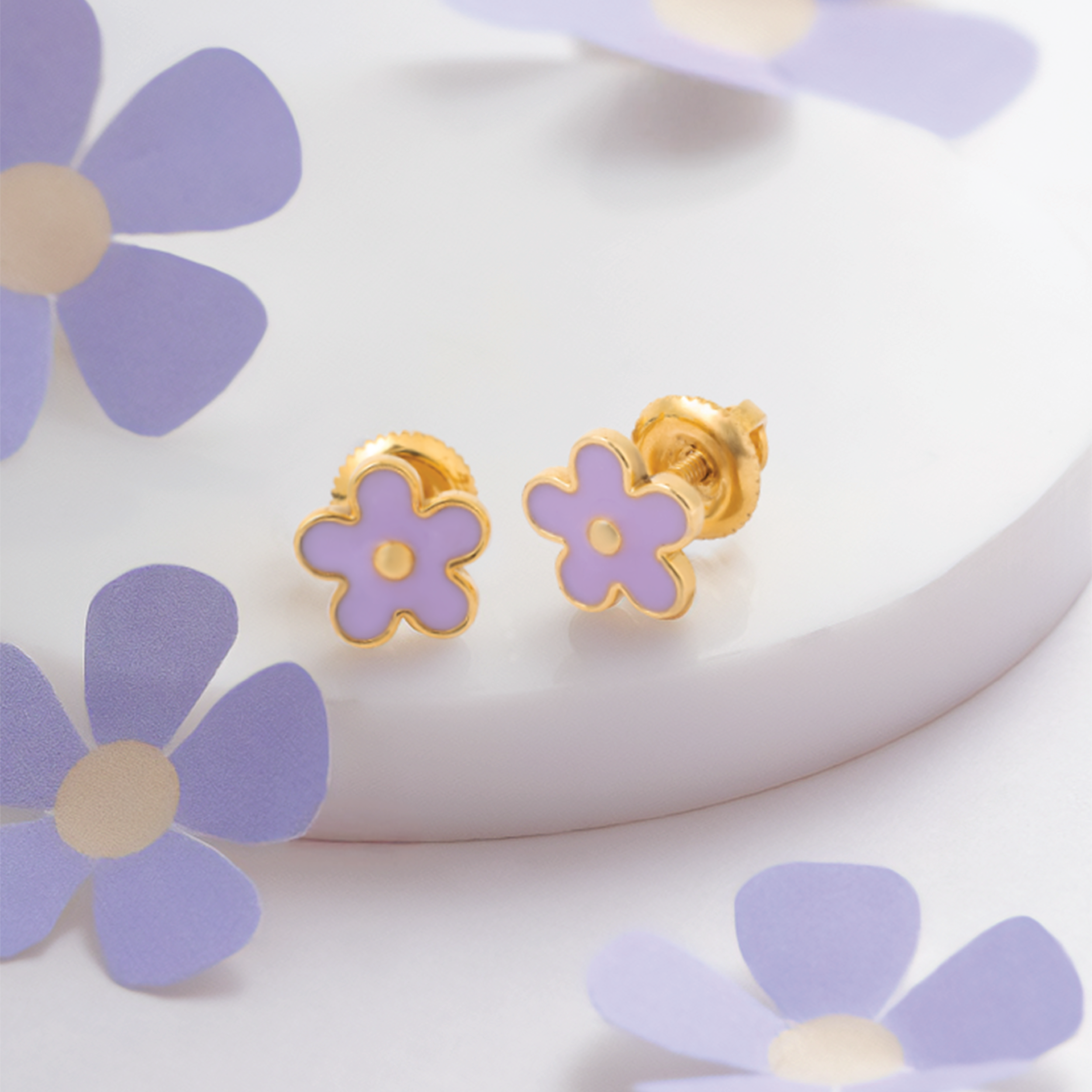 Tiny Jewels flower-shaped earrings with gold rims on a white background with purple flowers.