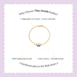 Tiny Jewels gold bracelet with a crown charm on a light purple background, featuring text about Tiny Jewels Kadas.