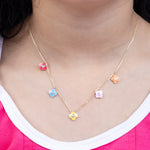 Tiny Jewels necklace with colorful flower pendants worn by a person