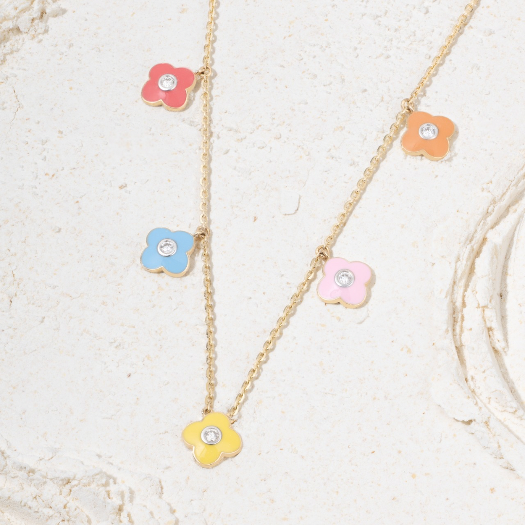 Tiny Jewels necklace with colorful flower pendants on a light background
