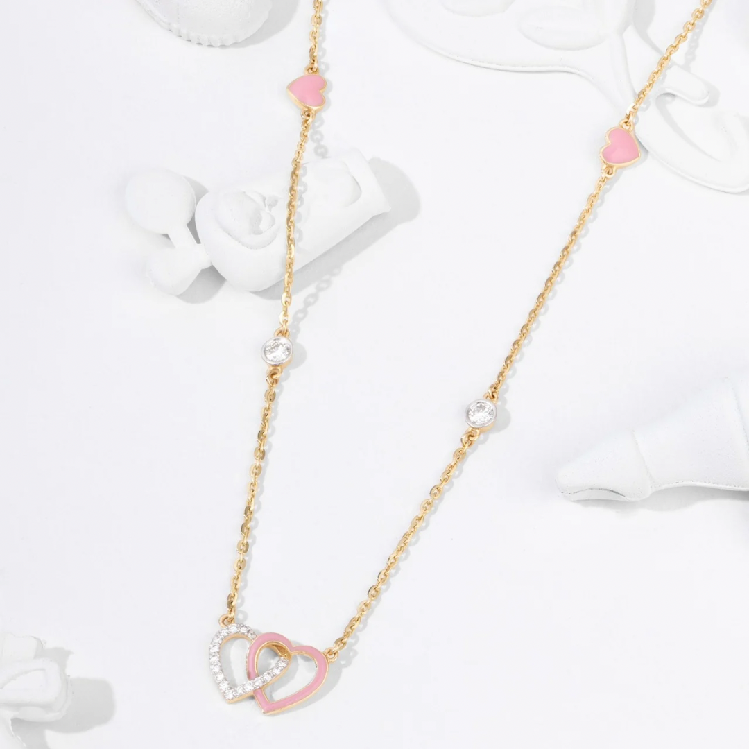 Tiny Jewels necklace with pink heart-shaped pendants on a white background
