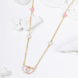 Tiny Jewels necklace with pink heart-shaped pendants on a white background