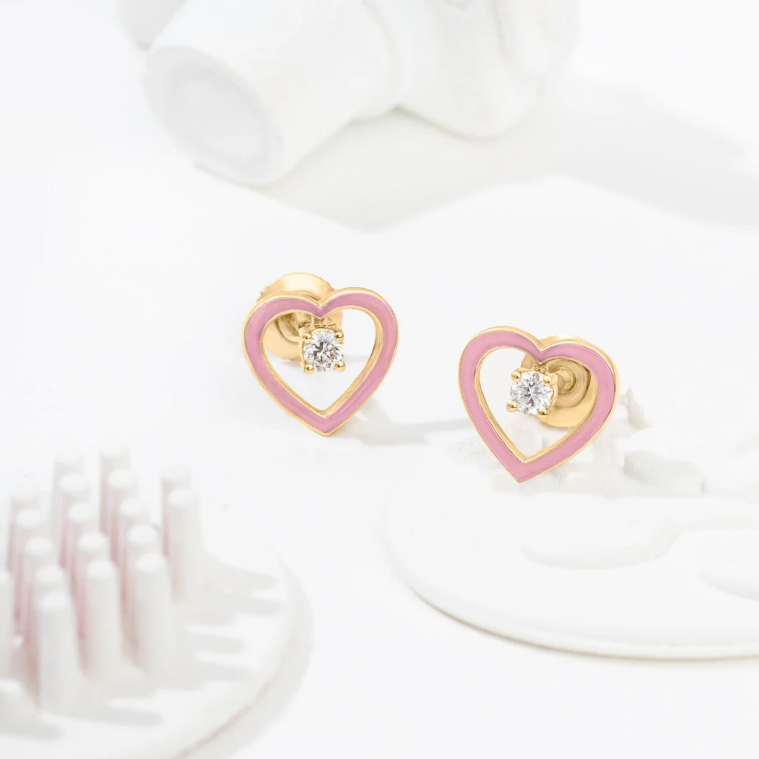Tiny Jewels heart-shaped earrings with pink and gold design on a white background