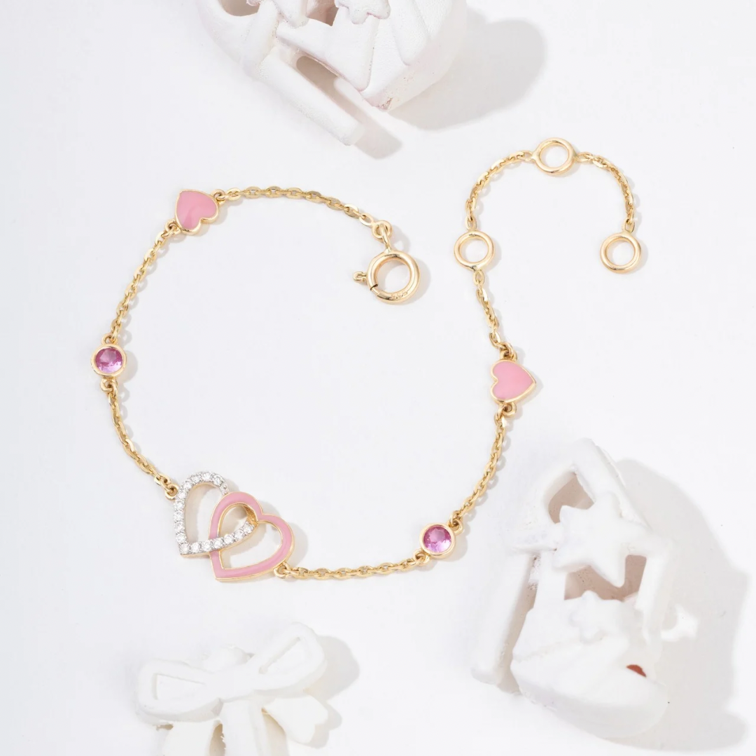 Tiny Jewels gold bracelet with heart-shaped pink beads on a white background