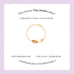 Tiny Jewels gold bracelet with a fox charm on a white background with text about Tiny Jewels Kadas.