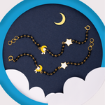Tiny Jewels bracelet with moon and star charms on a blue and white background