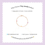 Tiny Jewels bracelet with colorful beads on a light purple background with text about Tiny Jewels Kadas.