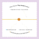 Tiny Jewels gold bracelet with a flower charm on a white background with promotional text about Tiny Jewels Kadas.