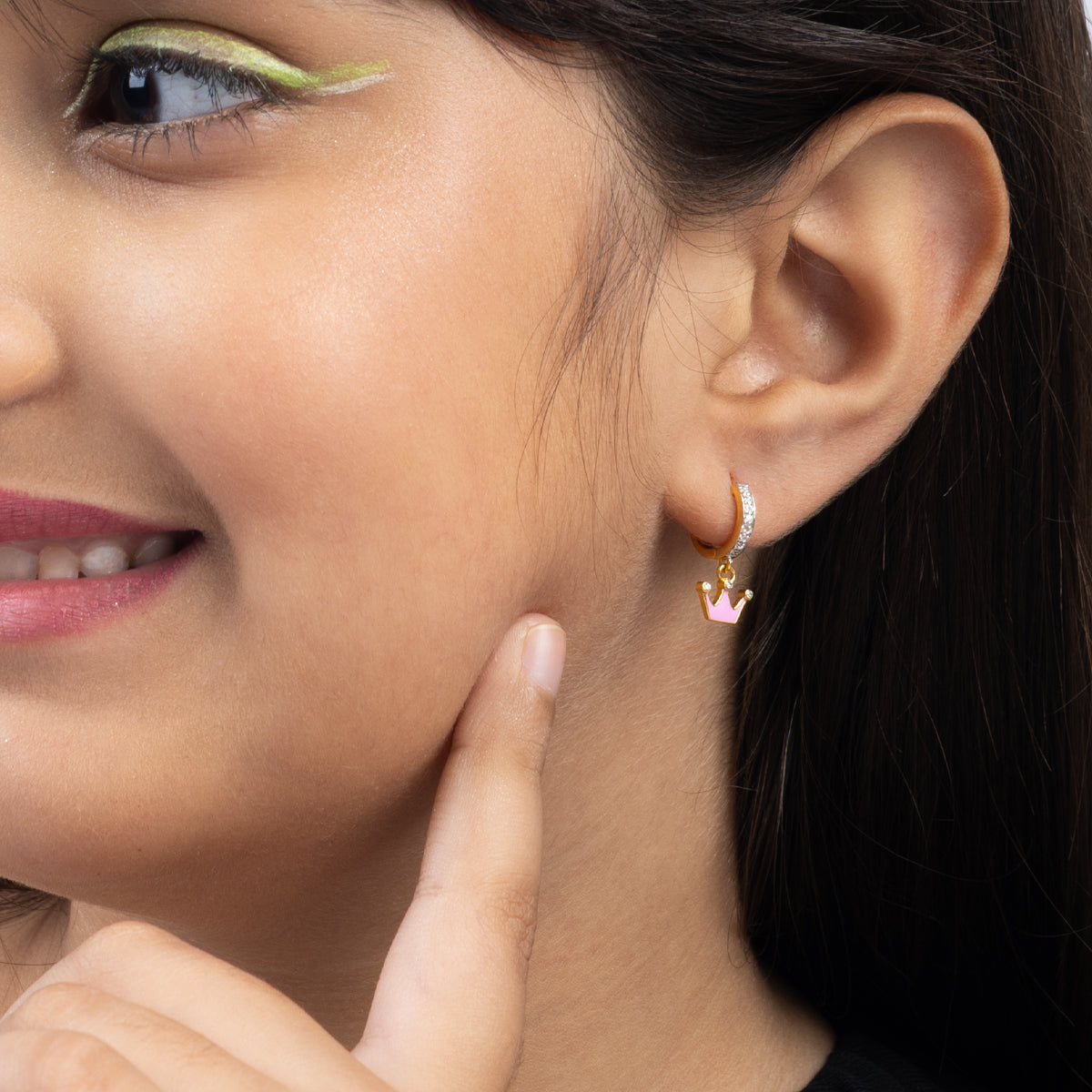 Tiny Jewels close-up of a woman wearing a gold and pink earring.
