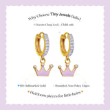 Tiny Jewels gold hoop earrings with pink crowns on a white background with text about Tiny Jewels Balis.