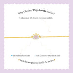 Tiny Jewels advertisement for Tiny Jewels Kadas bracelet with gold chain and heart charm on a light purple background.