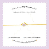 Tiny Jewels advertisement for Tiny Jewels Kadas bracelet with gold chain and heart charm on a light purple background.