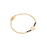 Tiny Jewels gold bracelet with black beads on a white background