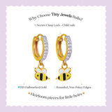 Tiny Jewels gold bee-shaped earrings with a purple background and text about Tiny Jewels Balis.