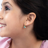 Tiny Jewels close-up of a woman wearing a colorful earring with a neutral background
