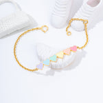 Tiny Jewels gold bracelet with colorful geometric beads on a white surface