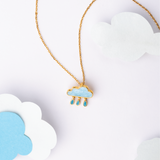 Tiny Jewels necklace with a cloud pendant featuring blue raindrops on a white background