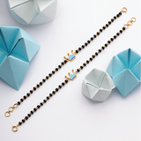 Tiny Jewels bracelet with crown charms and geometric paper sculptures on a white background