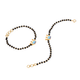 Tiny Jewels black beaded necklace with gold clasp on a white background