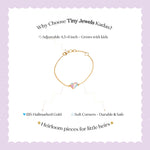 Tiny Jewels gold bracelet with colorful gemstones on a light purple background with text about Tiny Jewels Kadas.