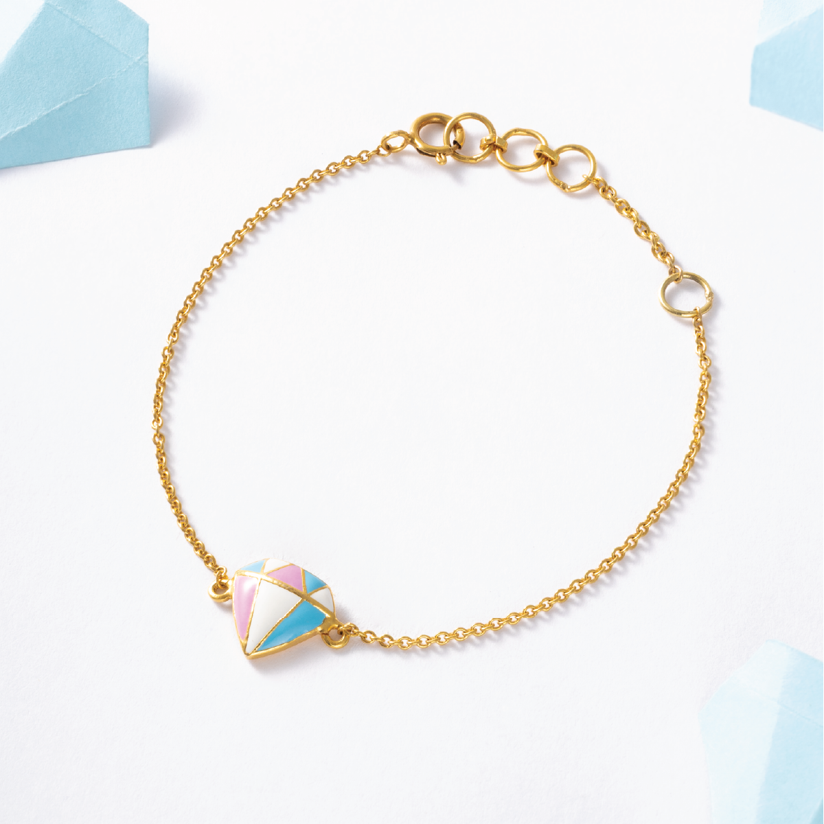 Tiny Jewels gold bracelet with a colorful triangle charm on a light background