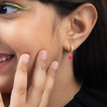 Tiny Jewels close-up of a woman wearing an earring with a pink star charm.