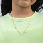 Tiny Jewels gold necklace with heart-shaped pendants worn by a person in a green shirt