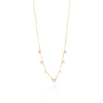Tiny Jewels gold necklace with heart-shaped pendants on a white background