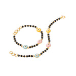 Tiny Jewels necklace with black beads, gold chain, and colorful evil eye charms on a white background