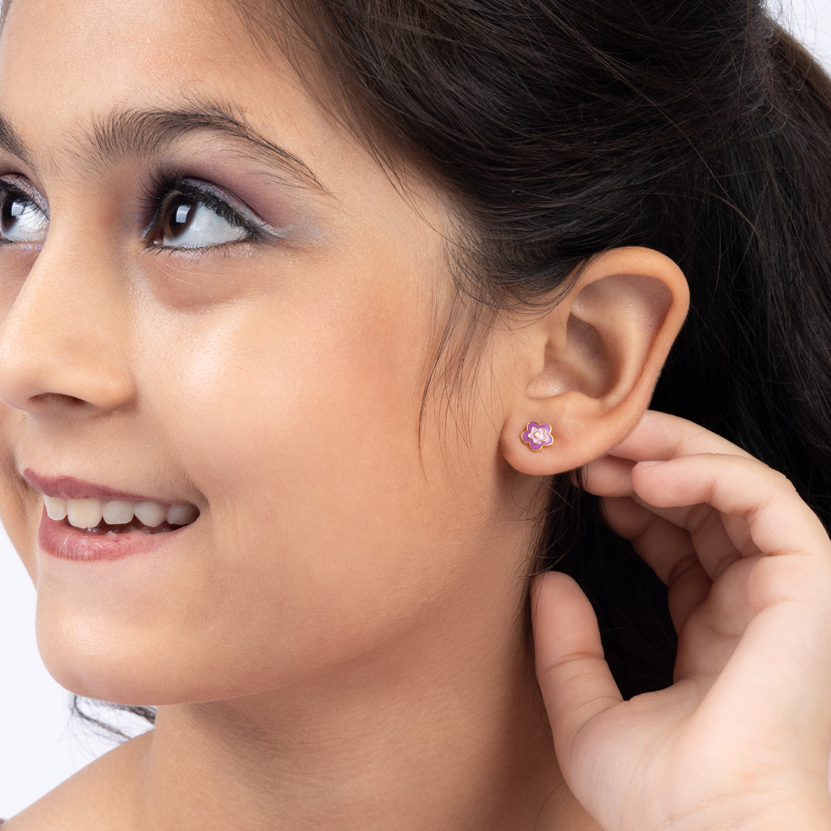 Tiny Jewels close-up of a young girl wearing a pink stud earring.