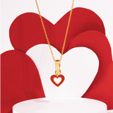 Tiny Jewels Gold necklace with a heart-shaped pendant on a red heart-shaped background