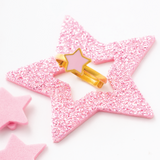 Tiny Jewels pink glittery star-shaped hair clips on a white background