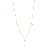 Tiny Jewels gold necklace with heart-shaped pendants on a white background