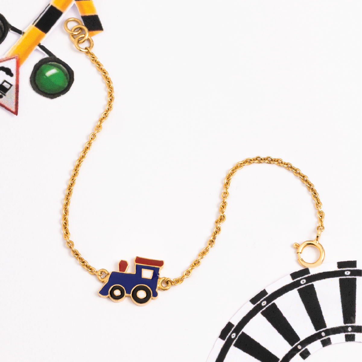 Tiny Jewels gold necklace with a blue train pendant on a white background